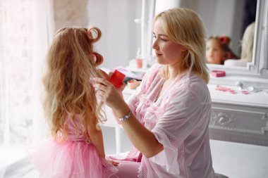 Anne ve kızı evde kafalarında bigudilerle