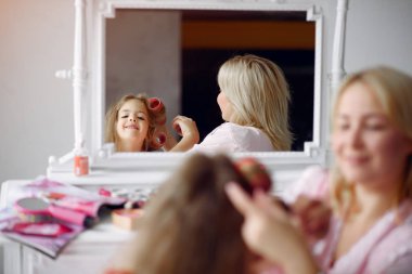 Anne ve kızı evde kafalarında bigudilerle