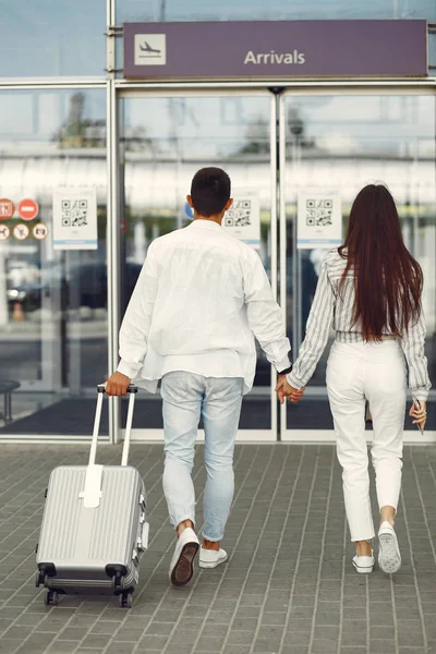 Krásný pár stojící v blízkosti letiště — Stock fotografie