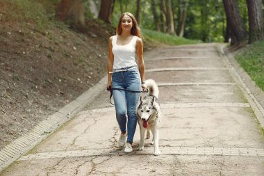 Bir bahar parkında tatlı bir köpekle oynayan kız.