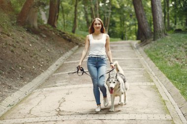 Bir bahar parkında tatlı bir köpekle oynayan kız.