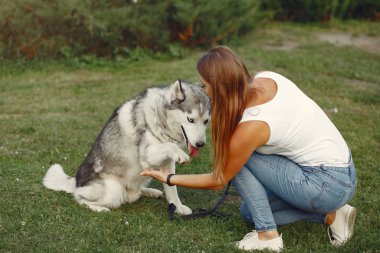 Bir bahar parkında tatlı bir köpekle oynayan kız.