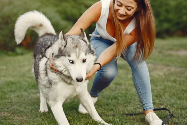 Дівчина в весняному парку грає з милою собакою — стокове фото
