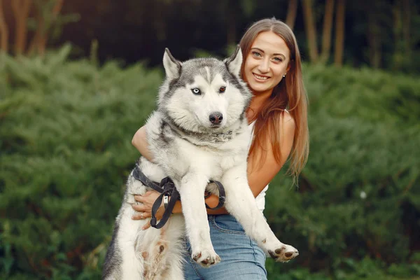 Flicka i en vårpark leker med söt hund — Stockfoto