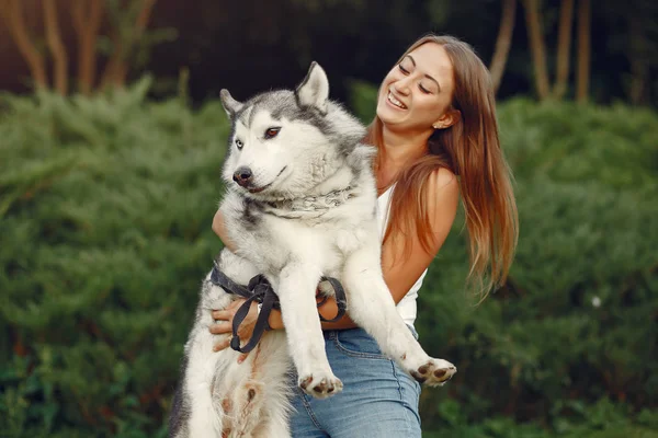 Flicka i en vårpark leker med söt hund — Stockfoto