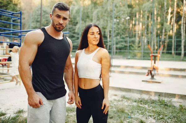 Beautiful couple training in a summer park — Stock Photo, Image