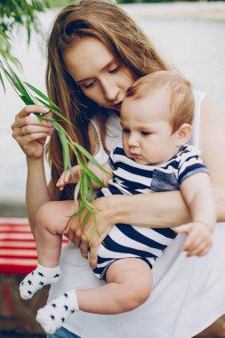 Anne ve oğlu parkta dinleniyor ve nehirde yürüyor..