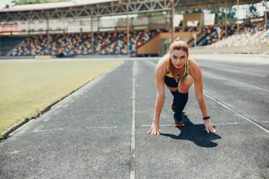 Stadyumdaki kız spor yapıyor.