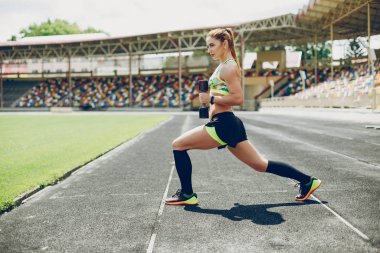 Stadyumdaki kız spor yapıyor.