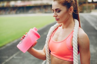 Stadyumdaki kız spor yapıyor.