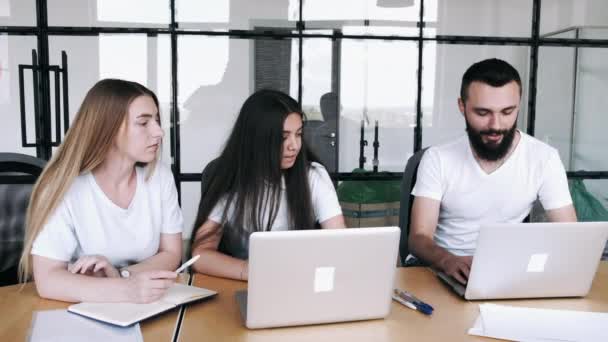 Kollégák, akik laptopokon dolgoznak egy modern irodai projekten — Stock videók