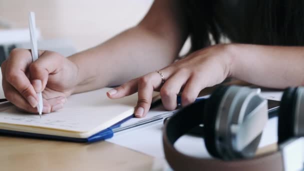 Primer plano de las manos femeninas sosteniendo la pluma y escribiendo notas — Vídeos de Stock