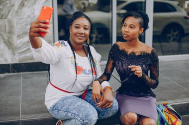 Kızlar şehrin sokaklarında yürüyor.