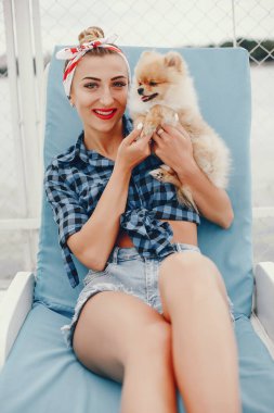 Küçük köpeği olan şık bir kız.