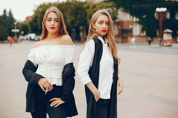 Twee stijlvolle meisjes in een zomerstad — Stockfoto