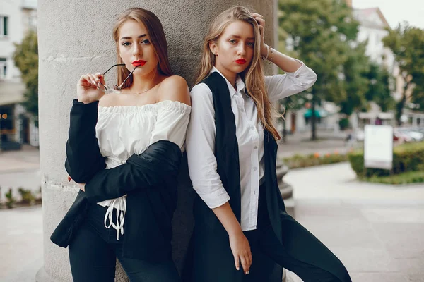 Twee stijlvolle meisjes in een zomerstad — Stockfoto