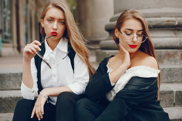 Twee stijlvolle meisjes in een zomerstad — Stockfoto