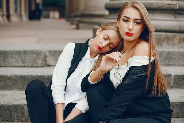 Twee stijlvolle meisjes in een zomerstad — Stockfoto