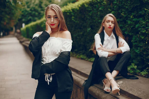 Twee stijlvolle meisjes in een zomerstad — Stockfoto