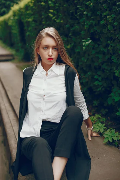Stilvolles Mädchen steht in einer Sommerstadt — Stockfoto