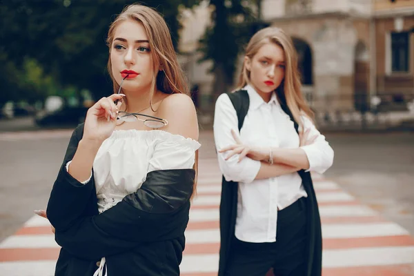 Twee stijlvolle meisjes in een zomerstad — Stockfoto