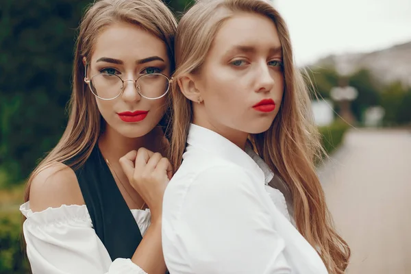 Twee stijlvolle meisjes in een zomerstad — Stockfoto