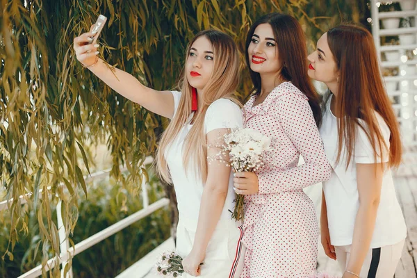 Belle ragazze in un parco estivo con un telefono — Foto Stock
