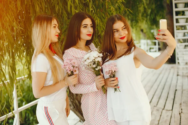 Chicas guapas en un parque de verano con teléfono —  Fotos de Stock