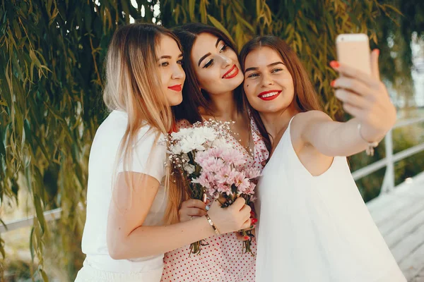 Pretty girls in a summer park with a phone