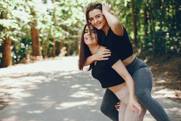 Beautiful sportsgirls in a summer sunny park — 스톡 사진