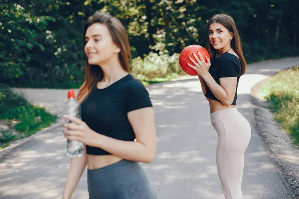 Beautiful sportsgirls in a summer sunny park — 스톡 사진