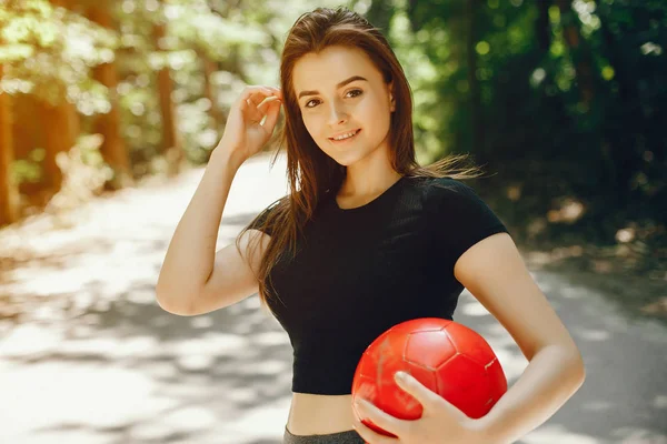 Beautiful sportsgirl in a summer sunny park — Stock Photo, Image