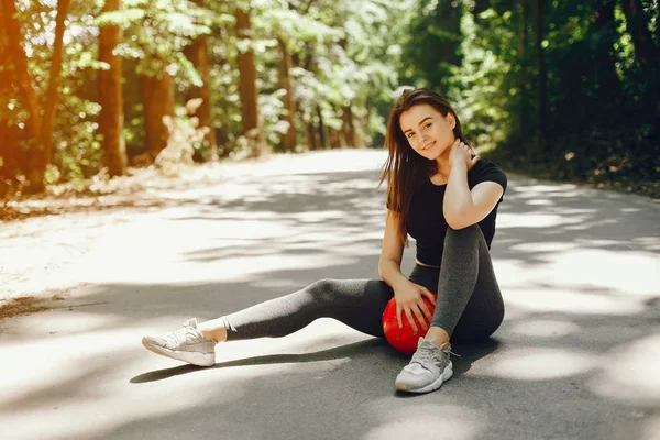 Beautiful sportsgirl in a summer sunny park — 스톡 사진