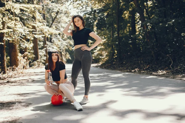 Lindas sportsgirls em um verão ensolarado parque — Fotografia de Stock