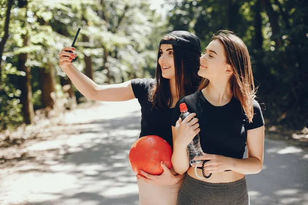 Lindas sportsgirls em um verão ensolarado parque — Fotografia de Stock