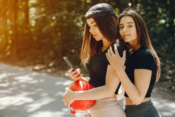 Lindas sportsgirls em um verão ensolarado parque — Fotografia de Stock