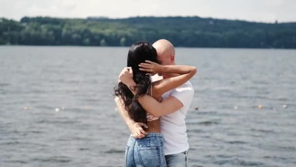 Man and woman huging each other near lake — Stock Video