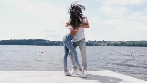 Erkek ve kadın göl kenarında dans edip eğleniyorlar. — Stok video