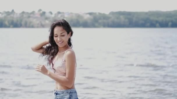 Porträtt av brunett kvinna på sjön bakgrund på sommaren — Stockvideo