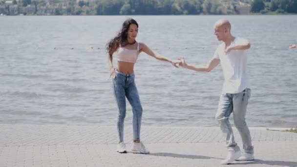 Pareja bailando cerca del lago en el parque en el día de verano — Vídeos de Stock