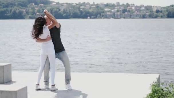 Homem e mulher ficando perto do lago abraçando uns aos outros — Vídeo de Stock