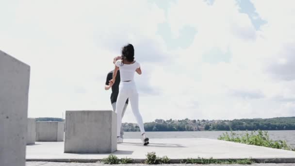 Couple actif ayant un entraînement de danse près du lac — Video