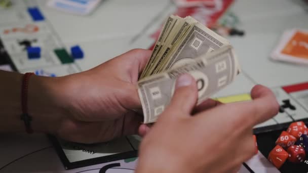 Empresa de amigos jogando monopólio no tempo livre em casa — Vídeo de Stock