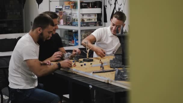 Friends playing role play game with miniatures at home — Stockvideo