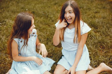 İki tatlı kız yaz parkında eğleniyor.