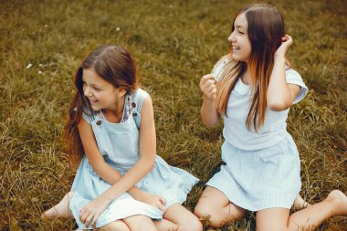 İki tatlı kız yaz parkında eğleniyor.