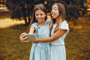 İki tatlı kız yaz parkında eğleniyor.