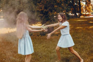 İki tatlı kız yaz parkında eğleniyor.