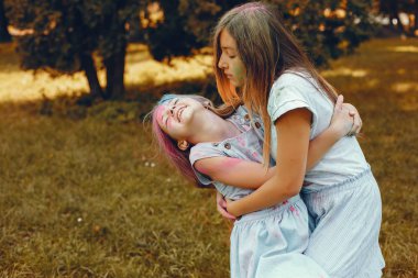 İki tatlı kız yaz parkında eğleniyor.