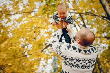 Sonbahar parkında oynayan sevimli bir aile.
